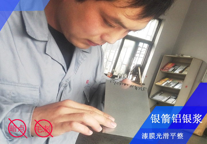 銀箭鋁銀漿工程師李工正在對(duì)發(fā)動(dòng)機(jī)殼烤漆漆膜看板檢測(cè)，確保漆膜光滑平整無(wú)暗點(diǎn)、無(wú)毛刺